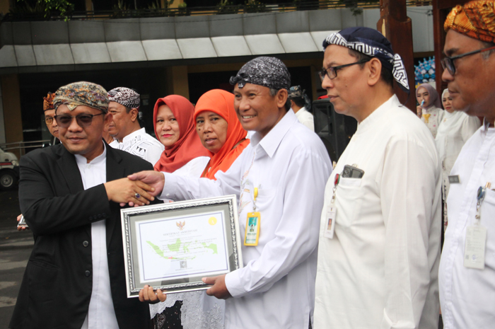PENUHI STANDAR: Pj Bupati Kudus M. Hasan Chabibie memberikan penghargaan perpustaakaan standar nasional kepada sepuluh sekolah di pendapa setempat pada Senin (23/9).