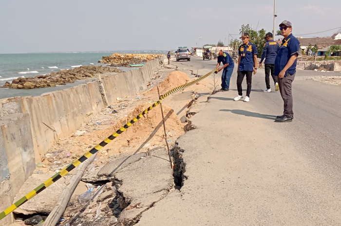 TERDAMPAK: Petugas Satpol PP Rembang mengecek dampak abrasi dari aktivitas penambangan pasir laut yang salah satunya berdampak pada amblesnya jalan lingkar di Sarang.