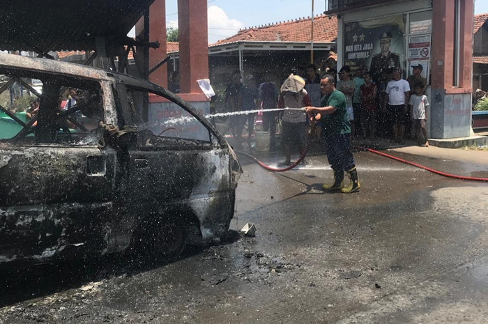 TAK TERSISA: Petugas Damkar unit Kalinyamatan padamkan mobil Daihatsu Espass yang terbakar kemarin.