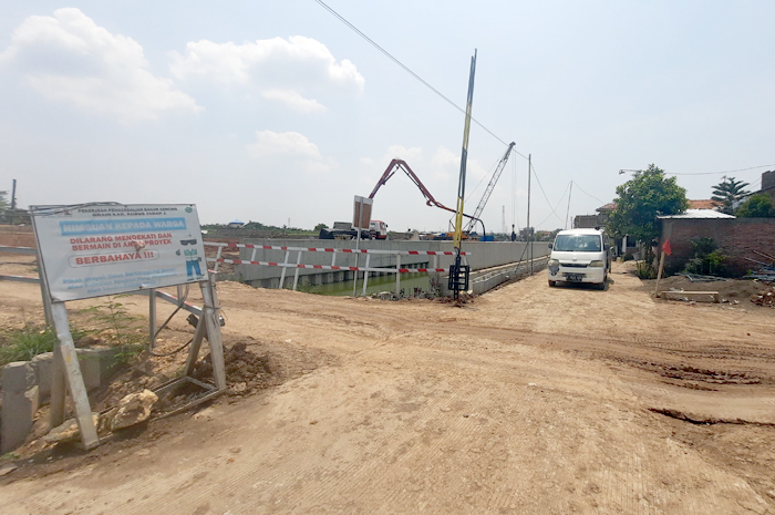 LIHAT LOKASI: Jalan umum terkena ceceran tanah dari proyek kolam retensi di Desa Jati Wetan, Kecamatan Jati.