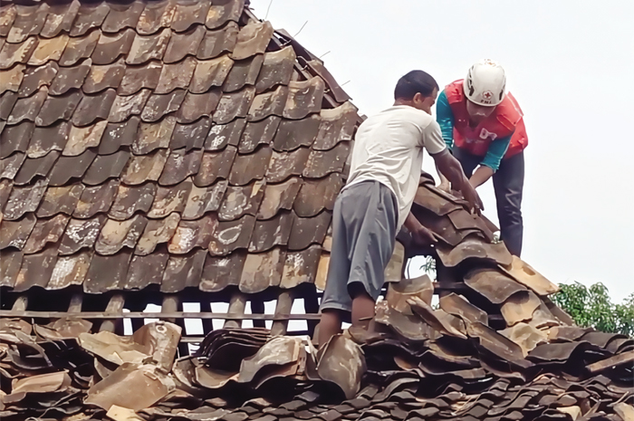 SIGAP: Masyarakat saat gotong royong memperbaiki atap rumah yang rusak kemarin.