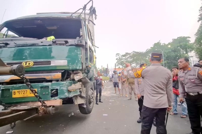 Polisi melakukan evakuasi truk yang menabrak sejumlah pengendara.