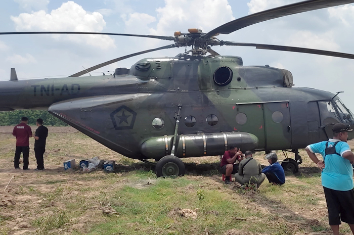 PENDARATAN: Helikopter jenis Mi 17 TNI AD mendarat darurat di area persawaahn Desa Kadengan, Randublatung