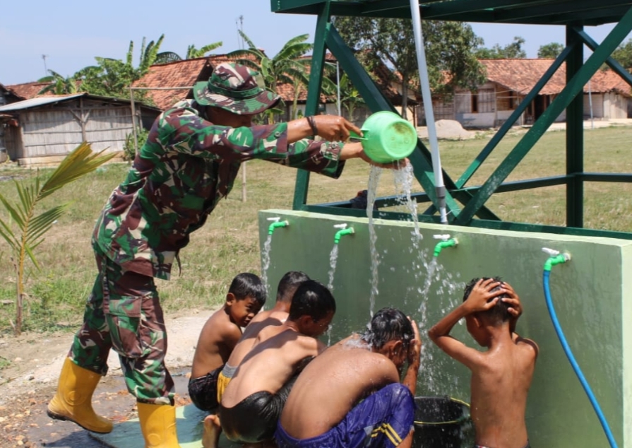 BAHAGIA: Anak-anak saat mandi dari kran yang airnya bersumber dari sumur bor hasil TNI Manunggal Membangun Desa (TMMD) ke-122 Kodim 0721/Blora.