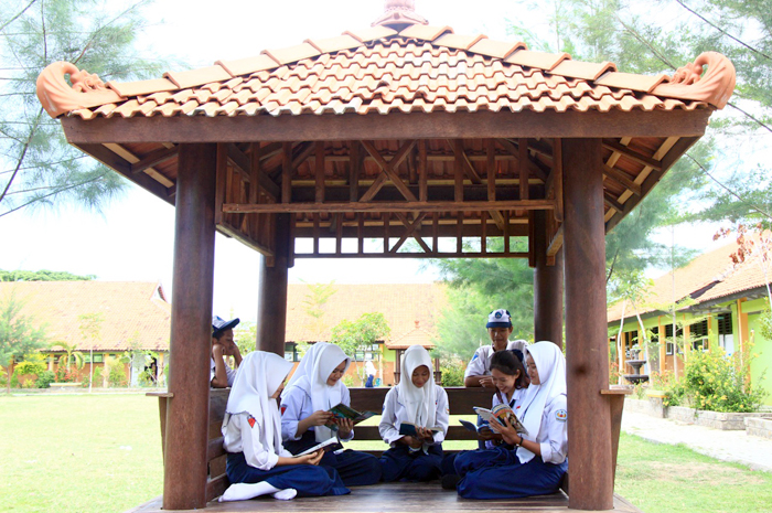 TINGKATKAN LITERASI: Siswa SMPN 2 Kragan menyempatkan waktu istirahat dengan membaca di areal gazebo di halaman dalam sekolah.
