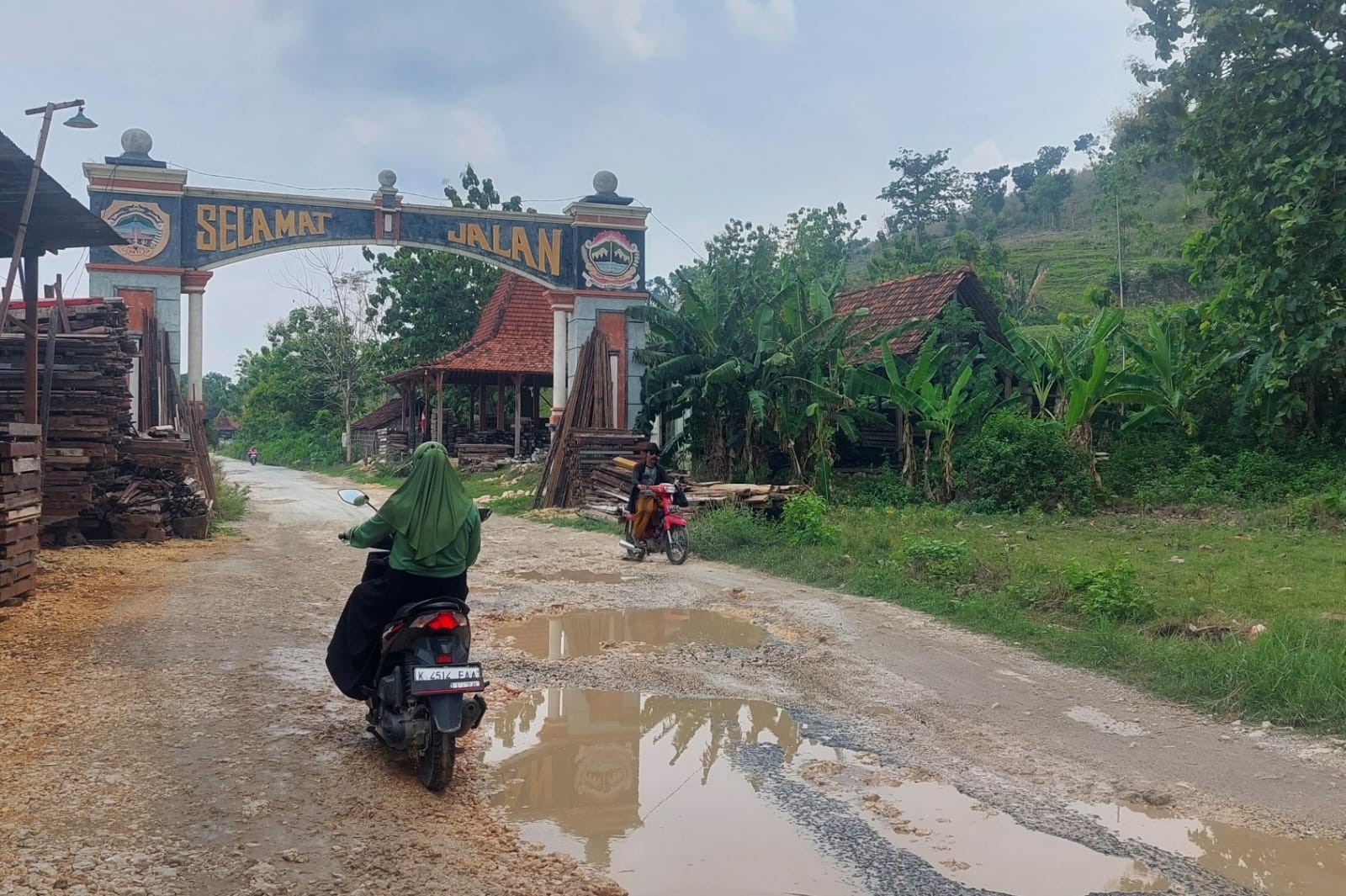 BERLUMPUR: Pengendara melintasi ruas jalan Sukolilo-Prawoto yang becek kala hujan pada 13 November 2024.&nbsp;