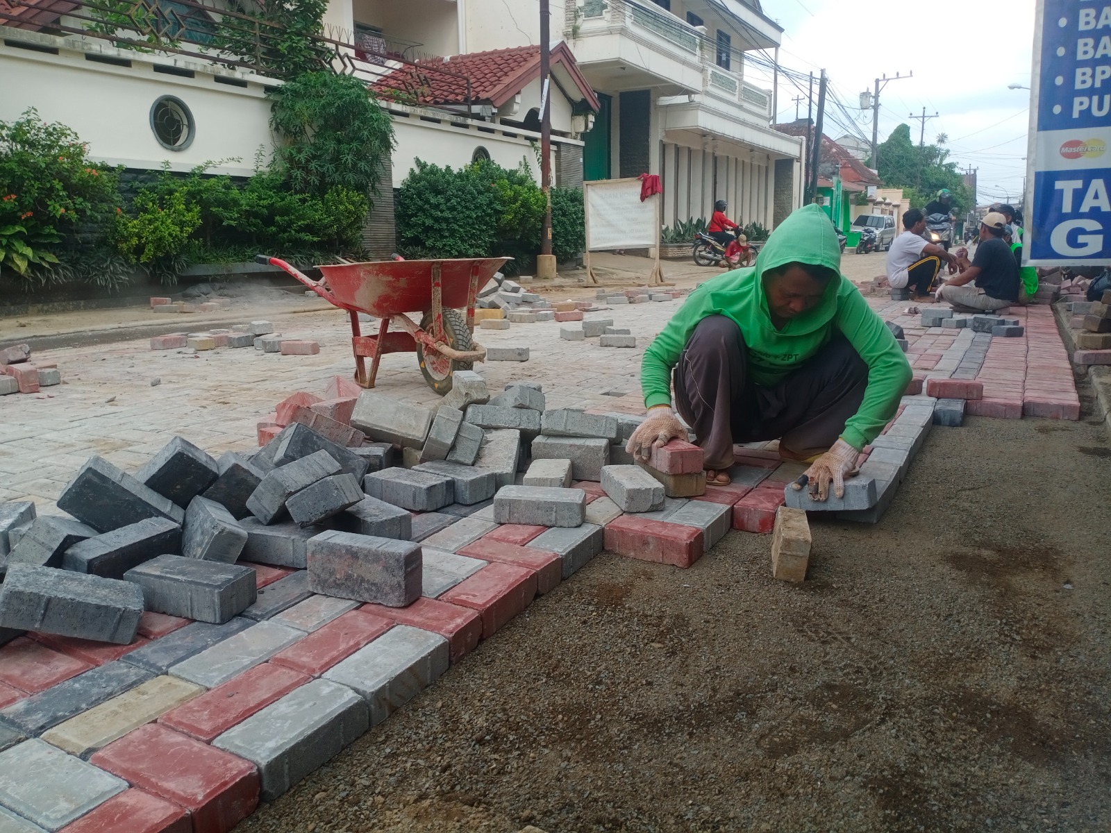 BANGUN INFRASTRUKTUR: Sejumlah memasang paving Jalan KH Ahmad Dahlan.
