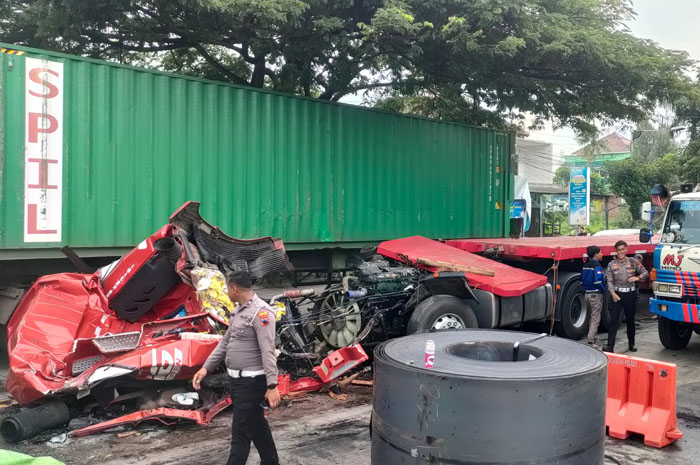 TAK BERBENTUK: Kondisi kabin truk tronton bermuatan gulungan baja sudah tak berbentuk setelah dihantam muatannya, Selasa (2/12).