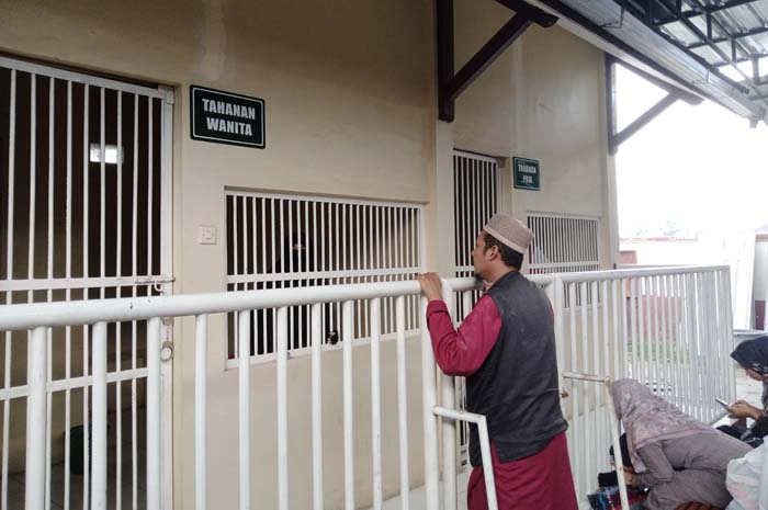 PRIHATIN: Bambang Lukito saat menengok istrinya, Afrida Mahyeni Nasution di ruang tahanan setelah mengikuti sidang putusan di PN Blora.