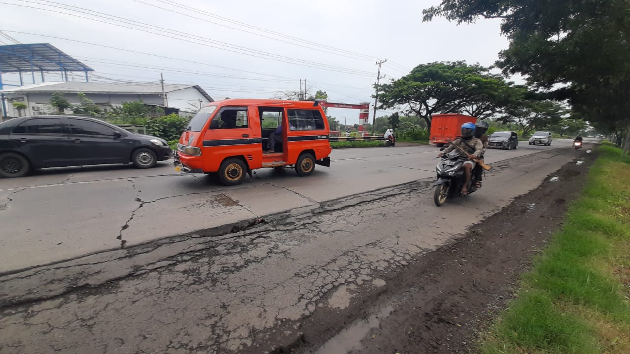 RUSAK PARAH: Pengendera sepeda motor melintas di Jalur Pantura Pati &ndash; Juwana di sekitar Desa Widorokandang &ndash; Purworejo.