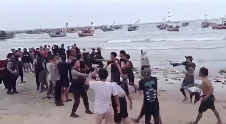 ADU JOTOS: Personel polisi terlihat berusaha melerai massa yang tawuran di area pantai saat orkes dangdut di Desa Kranganyar, Kecamatan Kragan.