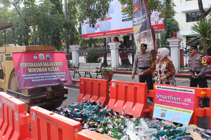 DIGILAS: Ribuan miras dimusnahkan dengan dihancurkan menggunakan alat berat di jalan depan Setda Grobogan, Jumat (20/12).