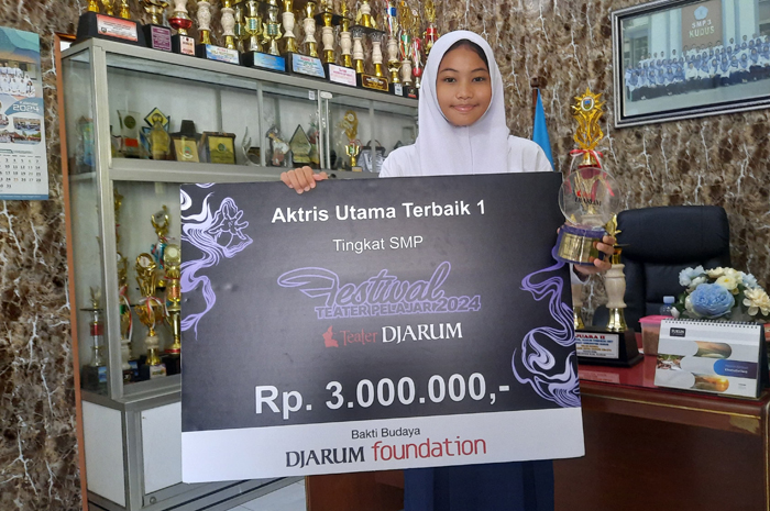 MEMBANGGAKAN: Savira Ramadani Harto, siswa SMPN 3 Kudus menunjukkan trofi di ruang kepala sekolah kemarin.