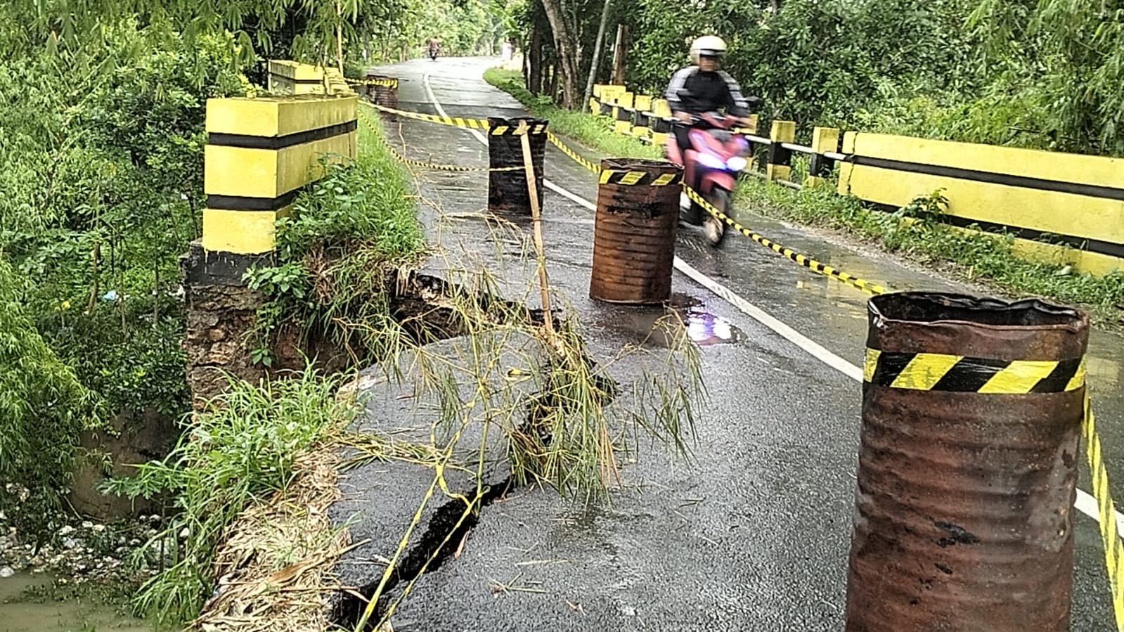 LONGSOR: Seorang pengendara melewati jalan di kawasan jembatan Kalirejo, Kecamatan Banjarejo, longsor pada Jumat, 20 Desember 2024.