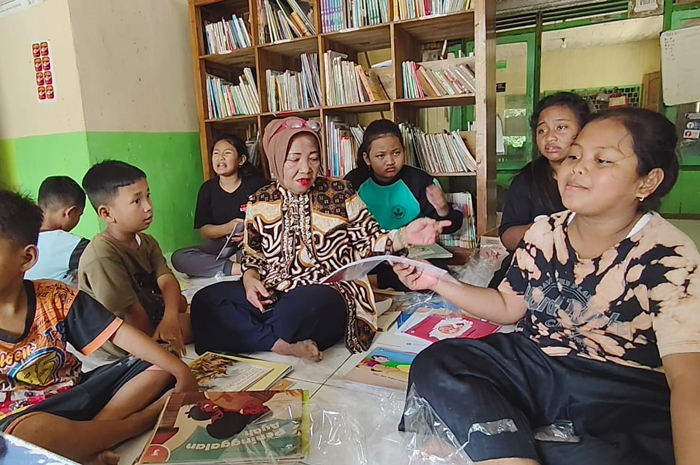 PENGGERAK: Inayati di rumahnya dijadikan TBM Merti Lestari bersama dengan anak-anak sekitar membaca buku untuk mengisi liburan sekolah.
