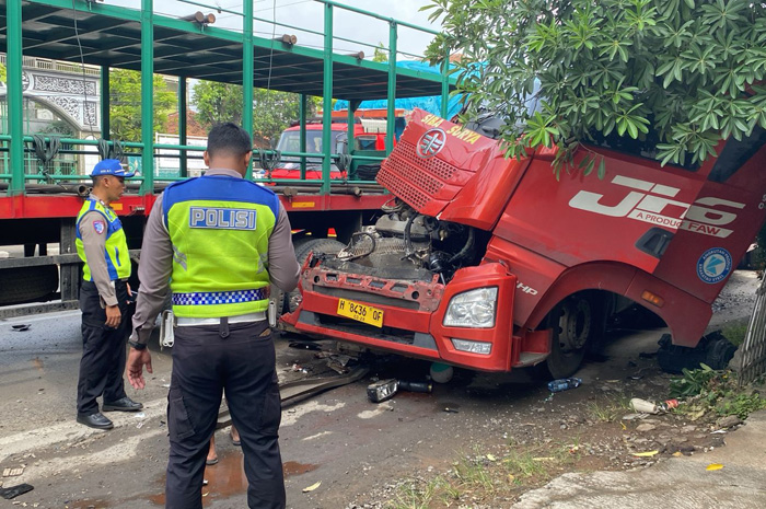 DIEVAKUASI: Polisi menunjukkan truk yang mengalami kecelakaan beruntun.