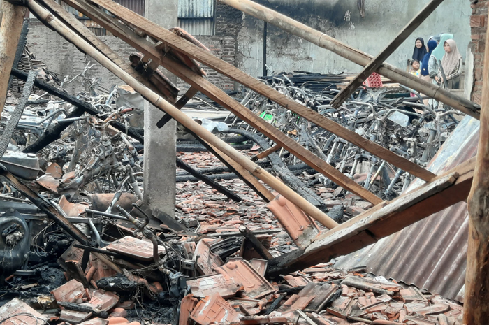 TINGGAL KERANGKA: Warga melihat kondisi lokasi titipan sepeda dan motor yang terbakar di Desa Bulungcangkring, Jekulo, Kudus.