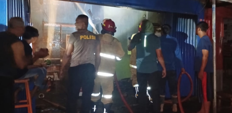 PADAMKAN: Petugas pemadam kebakaran bersama anggota Polsek Klambu memadamkan api di salah satu Ruko Pasar Klambu, Rabu malam (1/1).