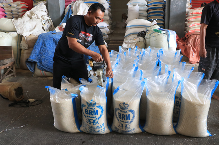 NAIK: Pedagang di Pasar Wergu Kudus mengemas beras kemarin. Beras saat ini mengalami lonjakan harga hingga dua ribu per kilogramnya.
