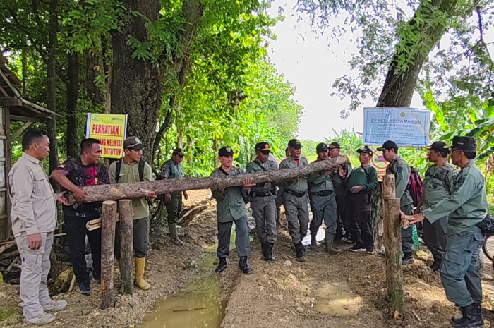 ANGKAT BALOK: Sejumlah petugas KPH Purwodadi menutup jalan milik Perhutani dengan balok kayu setelah digunakan sebagai jalan galian C dari CV Asta Mulya Mandiri di Desa Kronggen, Kecamatan Brati.