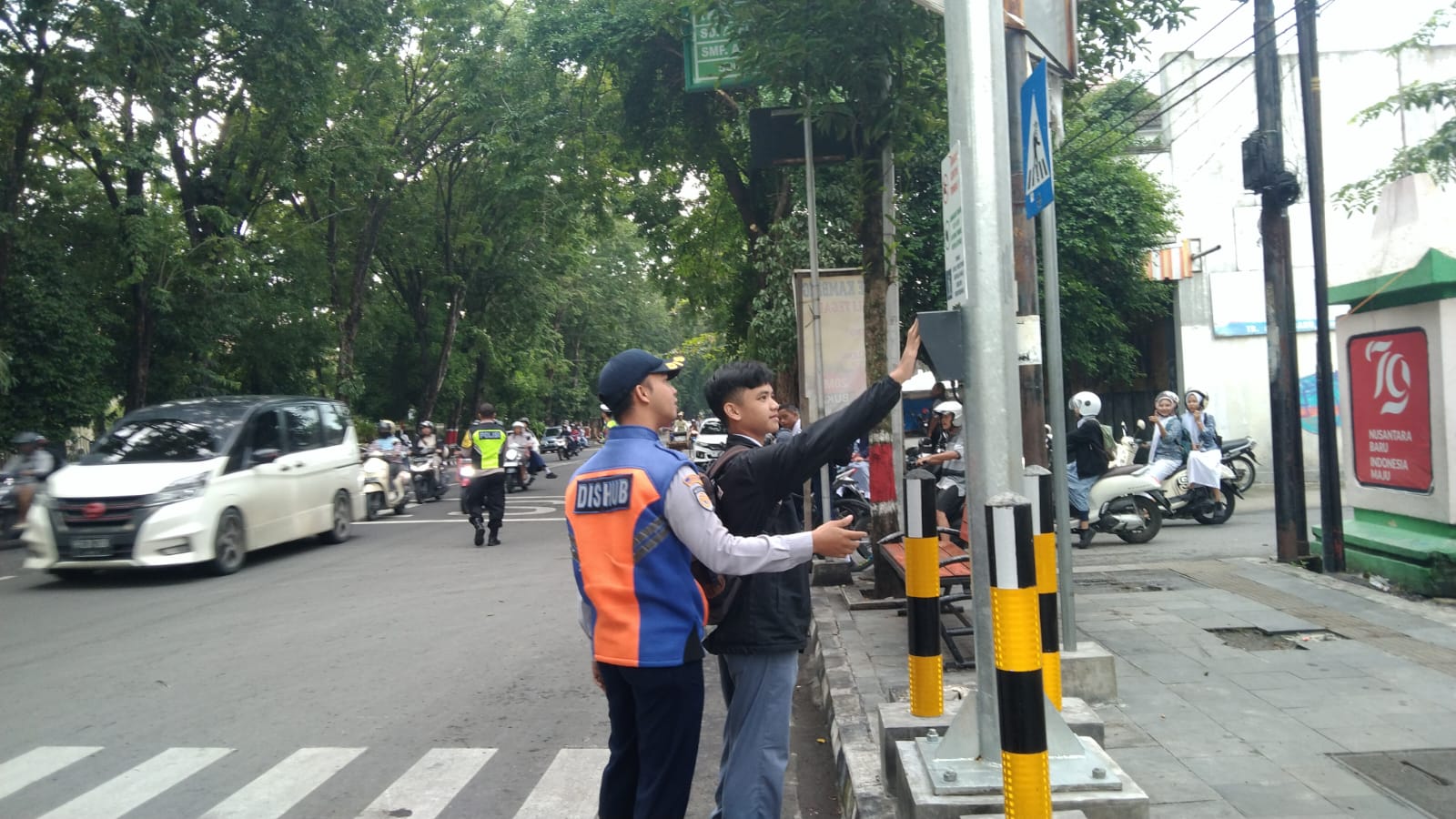 SOSIALISASI: Pelajar saat melambaikan tangan ke sensor tombol pelican crossing.