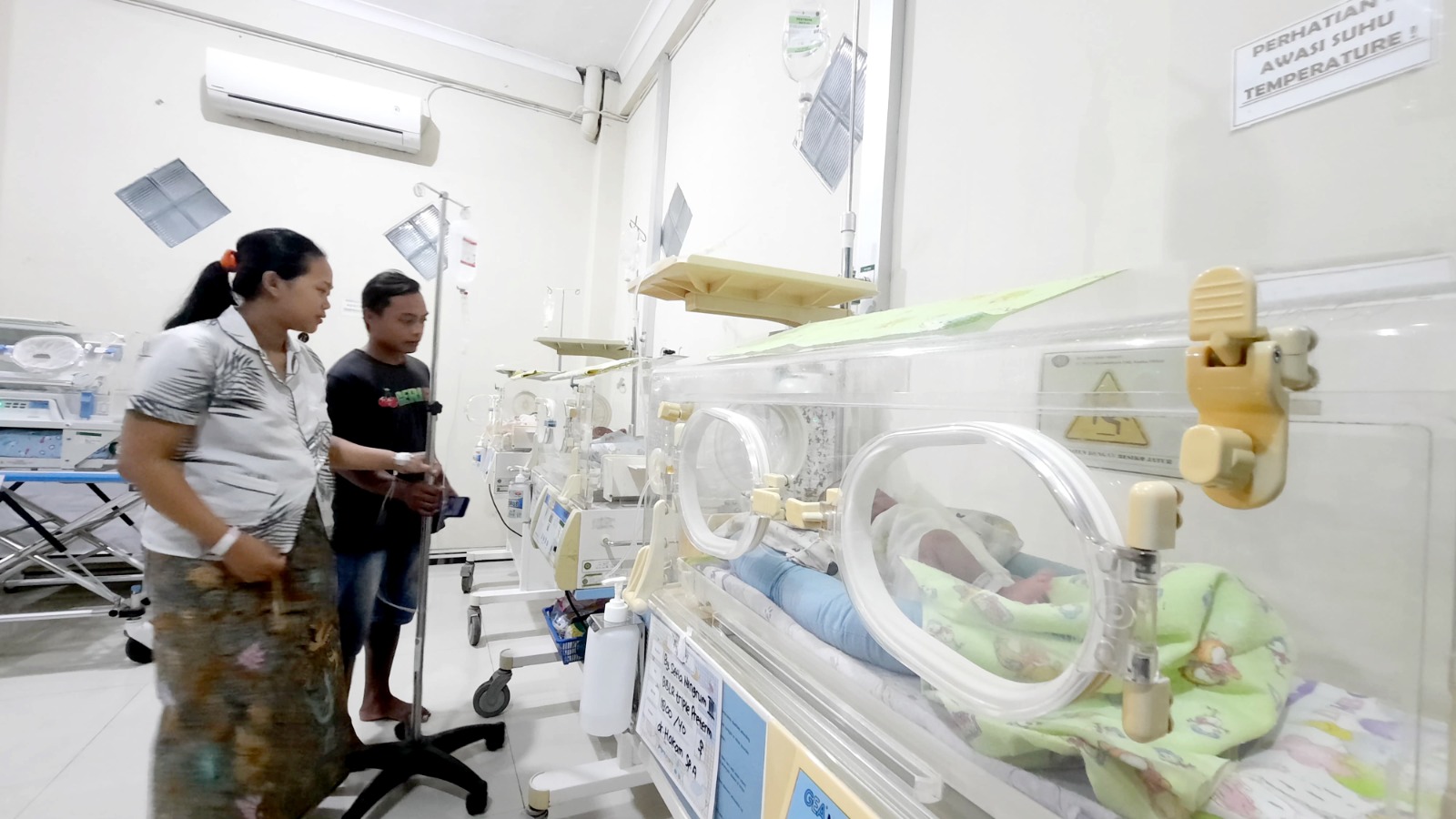 NENGOK SI KEMBAR: Setia Ningrum dan suami menjenguk anak kembarnya masih dalam perawatan intensif di ruang perinatologi di RS Aisyiyah Kudus.