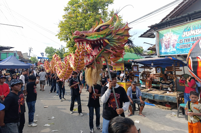 MERIAH: Salah satu rombongan kirab memasuki area makam Sunan Prawoto di Desa Prawoto Kecamatan Sukolilo, acara tahunan itu menyedot perhatian masyarakat.