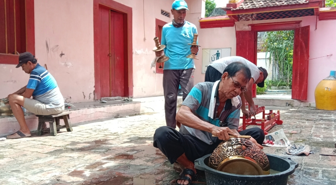 MENGGOSOK: Warga sedang membersihkan barang yang ada di Klenteng Cu An Kiong Desa Soditan, Lasem.