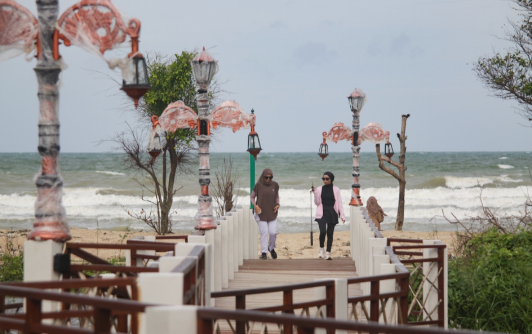 DAYA TARIK: Pengunjung bercengkerama di boardwalk yang ada di Pantai Bandengan Jepara.