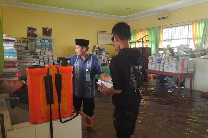 BANJIR: Sejumlah siswa saat membantu mengamankan sejumlah buku di ruang perpustakaan SMAN 1 Toroh.