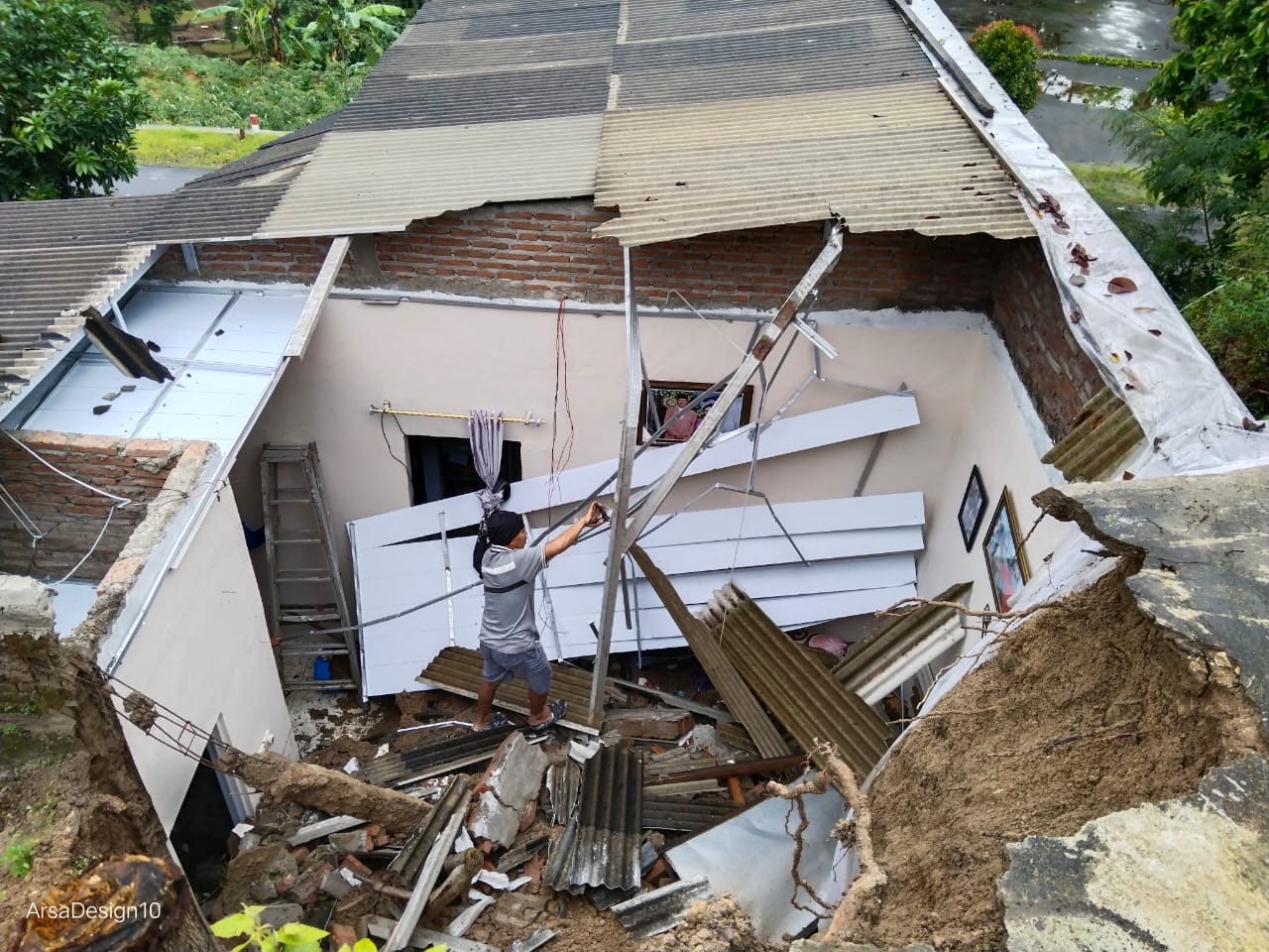 AMBROL: Seorang warga mengecek kondisi rumah Sulatri, warga Desa Jugo, Kecamatan Donorojo yang rusak ditimpa tanah longsor pada Selasa, 21 Januari 2025.