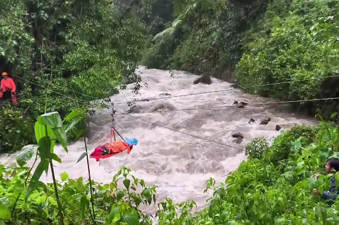 DRAMATIS: Proses evakuasi korban selamat menggunakan tandu merintangi aliran sungai yang banjir di Dukuh Jabung Desa Tanjung, Kec. Pakisaji, Kab. Jepara.