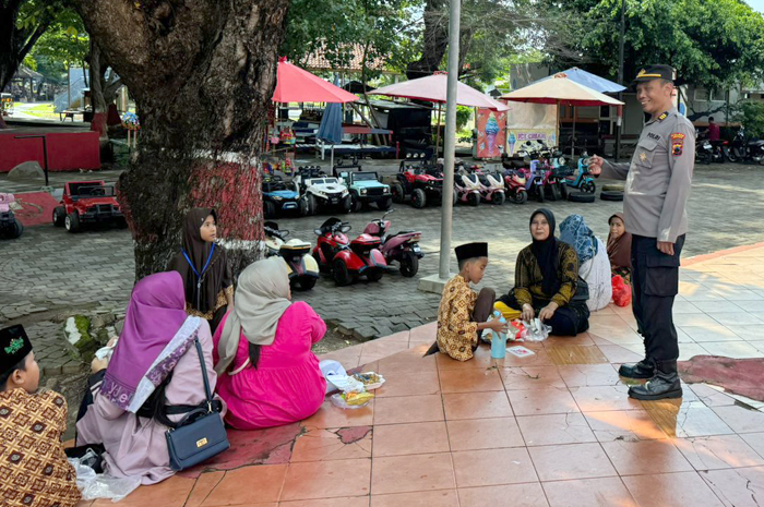 PATROLI: Seorang anggota polisi di Jepara sedang bercengkerama dengan masyarakat&nbsp;di tempat wisata.&nbsp;