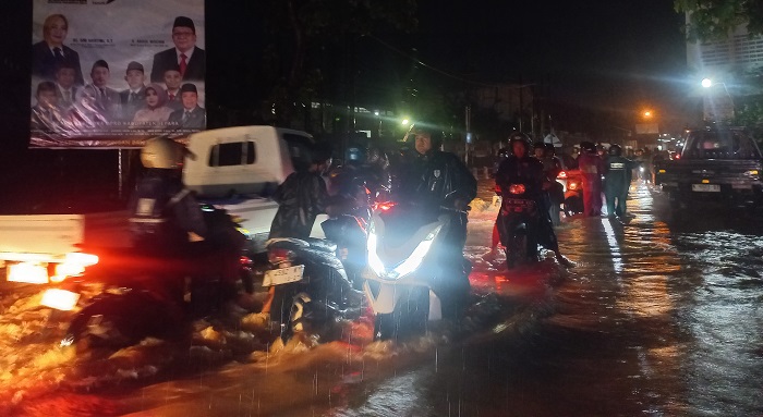 NEKAT: Para pengendara berusaha menerobos arus banjir pada Kamis (6/2) malam.
