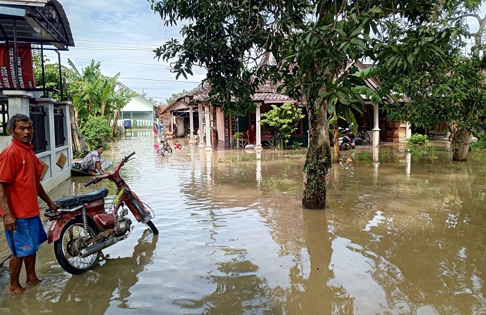 TERGENANG: Warga Desa Glonggong, Jakenan beraktifitas di tengah kebanjiran desanya kemarin.