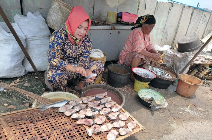 GARAP POTENSI: Warga di Desa Sarangmeduro, Sarang, melakukan pengasapan ikan.