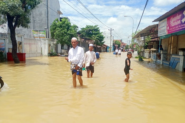 TAK KUNJUNG SURUT: Sejumlah warga Kecamatan Mejobo menuju masjid untuk menunaikan ibadah Salat Jumat berjalan kaki menerjang banjir di Perempatan Mejobo kemarin.