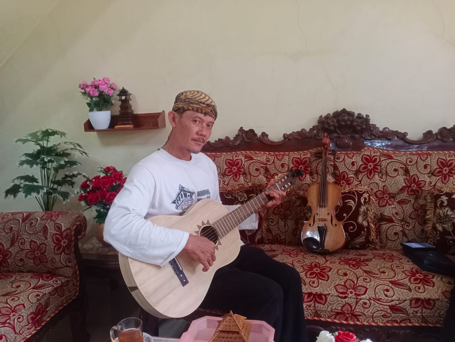 ANDIKA TRISNA SAPUTRA/RADAR KUDUS  MUSIK: Sejumlah pengunjung melihat perajin biola dan gitar bambu Ngatmin yang memainkan alat musik karyanya, belum lama ini.  &nbsp;