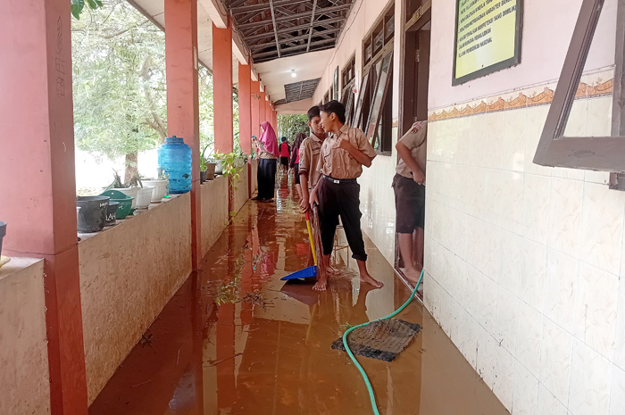 TAK ADA KBM: Siswa di SD 5 Ngembalrejo melakukan bersih-bersih kelas usai kebanjiran kemarin pagi.