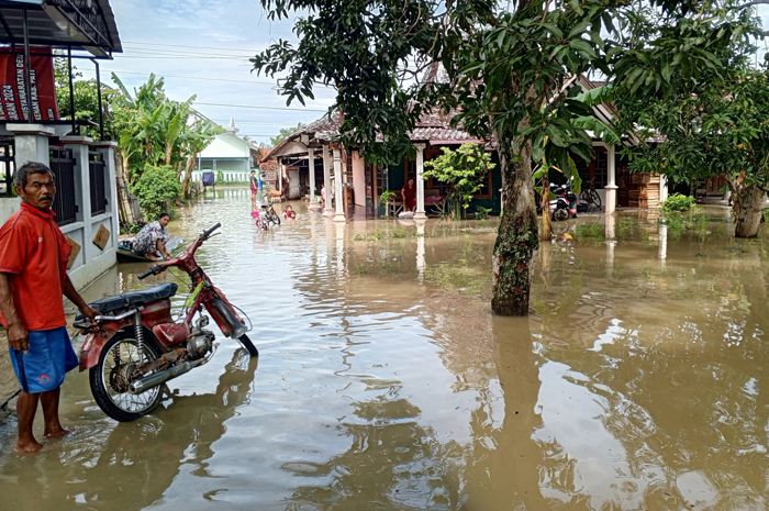 TERGENANG: Warga Desa Glonggong, Jakenan beraktifitas di tengah kebanjiran desanya kemarin.