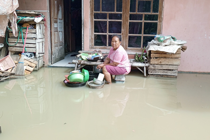 KEBANJIRAN: Warga Jakenan mencuci perabotan di tengah banjir yang merendam rumahnya pada awal pekan ini.
