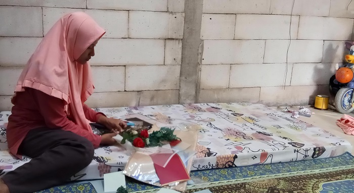 DIRANGKAI: Umi Musyarofah, salah satu guru TK di Tambakromo merangkai bunga ke buket di kediamannya Desa Karangmulyo, Tambakromo pada Sabtu (15/2) sore.