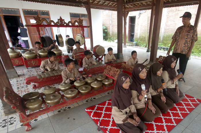 PEDULI KESENIAN: Nur Sholeh, Petinggi Bantrung meninjau kegiatan latihan gamelan yang diikuti anak-anak di Balai Desa Bantrung, Batealit. antrung, Batealit.