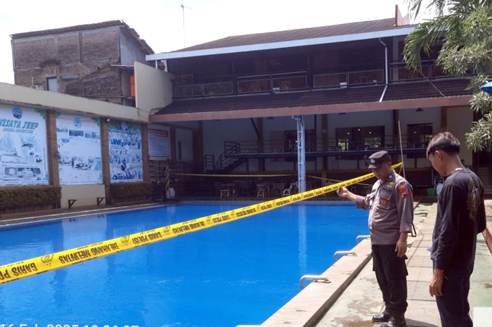 DITUTUP: Polisi mengecek lokasi tenggelamnya seorang bocah 8 tahun di kolam renang Andina, Minggu (16/2).