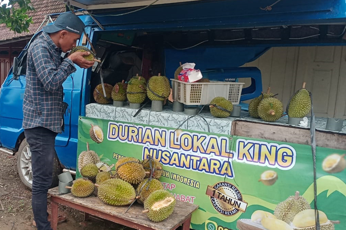MEROSOT: Pedagang durian di Gunungwungkal memperlihatkan stoknya kepada pembeli dia mengeluhkan pasokan durian yang menurun tahun ini.