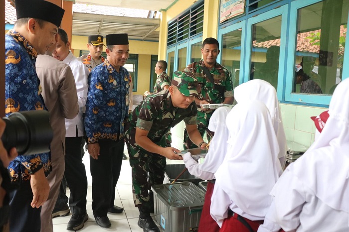 RAMAH: Komandan Kodim 0719/Jepara Letkol Arm Khoirul Cahyadi membagikan makanan kepada siswi penerima program MBG.