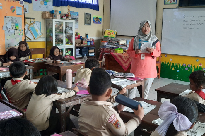 BELAJAR: Retna Andy Astrida guru Bahasa Inggris SD 1 Barongan Kudus saat memberikan pelajaran di kelas II-A di hadapan anak didiknya. &nbsp;