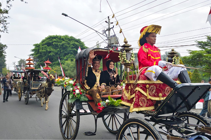 SAPA WARGA: Bupati Grobogan Setyo Hadi menyapa warga saat parade kereta kencana kuda menuju ke kantor Pendopo Kabupaten Grobogan dalam prosesi Boyong Grobog.