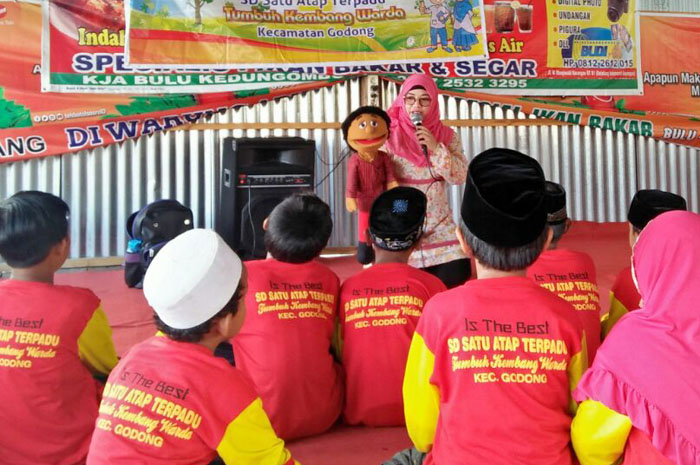 PUNYA CIRI KHAS: Yayang Dini Nur Frihartini, pendongeng asal Grobogan saat mendongeng di depan anak-anak menggunakan boneka.