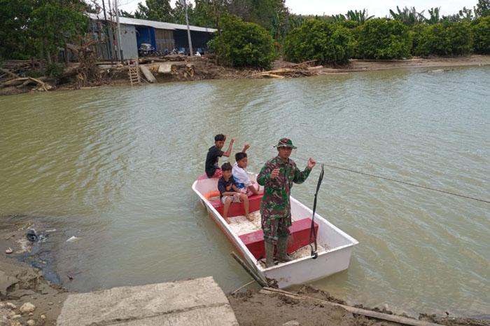 TERISOLASI: Warga Dusun Mintreng Desa Baturagung Kecamatan Gubug saat memanfaatkan perahu untuk menyebrang.